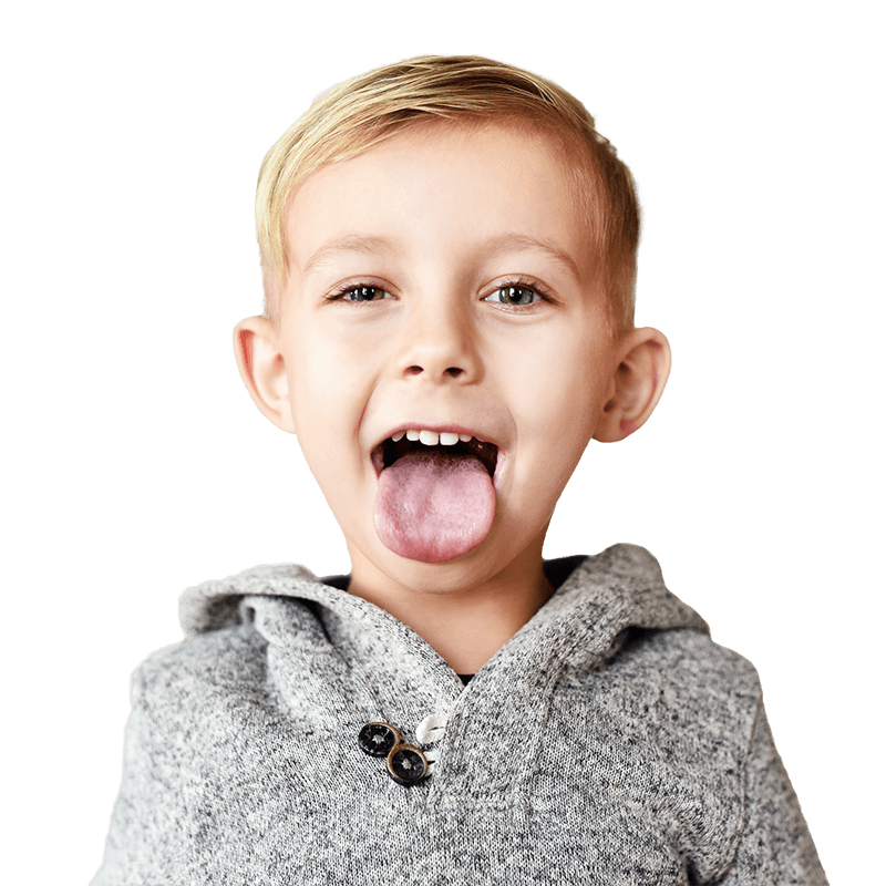 A boy in a gray hoodie holds his tongue out happily smiling with his mouth open.